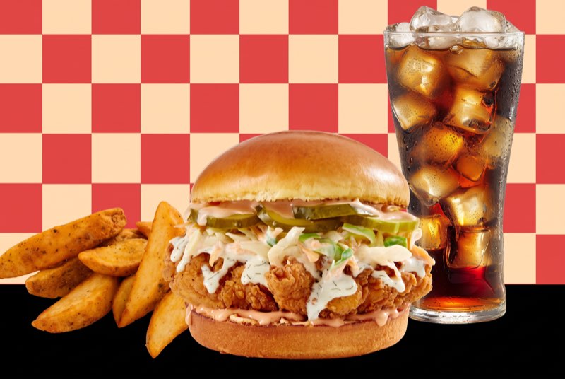 Classic Crispy chicken sandwich with potato wedges and a cola on a red and cream checkerboard
